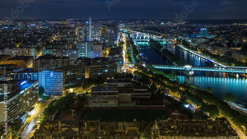 Aerial Night timelapse view of Paris City and Seine river shot on the top of Eiffel Tower