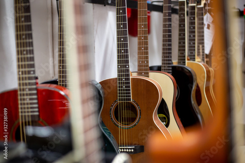 Close up of classic guitar drapped in a row in a huge musical shop, instrument shop, instrument concept