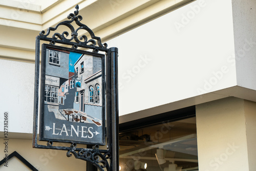 Obraz na plátně Brighton - December, 12: Traditional road name sign hang over the street in front of the lane alley famous shopping street place in Brighton, England