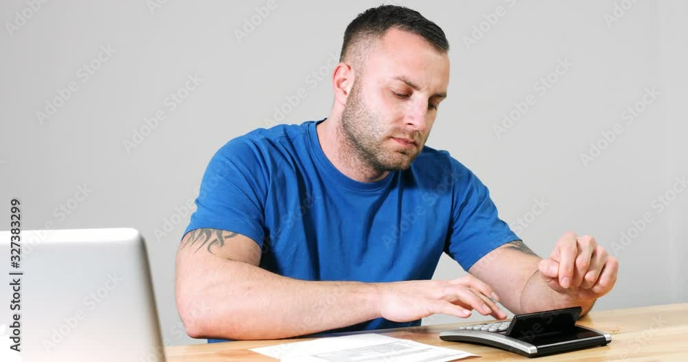 Man filling 1040 US tax day form by hand with calculator and laptop. Man filling 1040 US tax day form by hand with calculator and laptop.