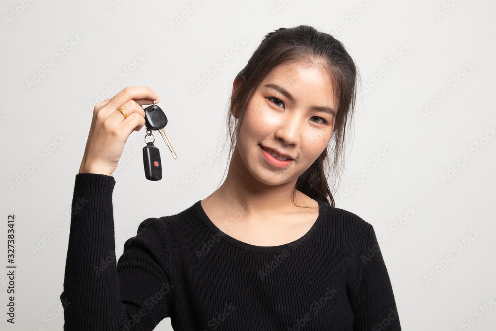 Cute asian girl showing home residence keys. Cute asian girl showing home residence keys.