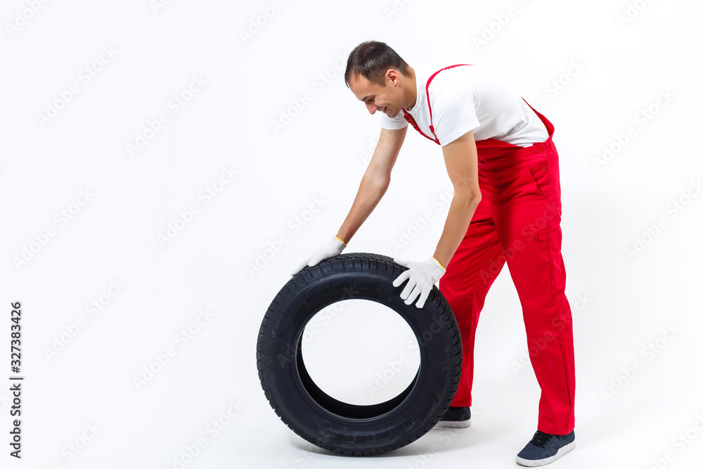 Mechanic holding a tire tire at the repair garage. replacement of winter and summer tires. Mechanic holding a tire tire at the repair garage. replacement of winter and summer tires.