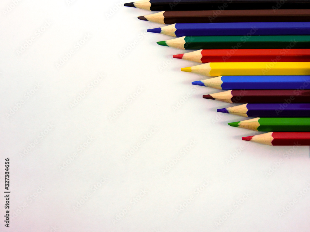 multicolored wooden pencils on a white sheet of paper multicolored wooden pencils on a white sheet of paper