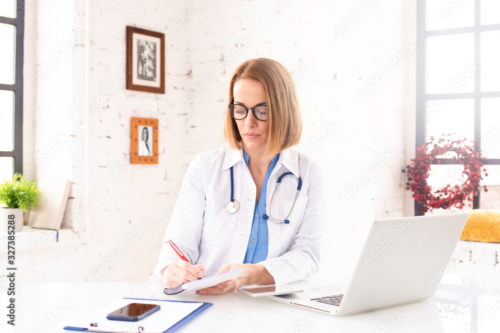 Mature female doctor working in doctor's office Mature female doctor working in doctor's office