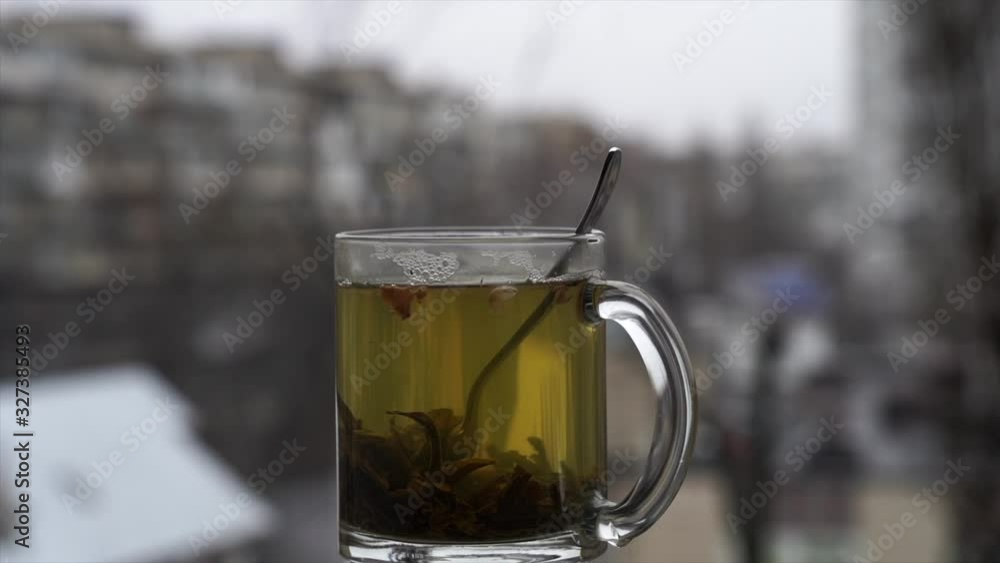 cup of hot tea on the daylight snowy cityscape background in slow motion cup of hot tea on the daylight snowy cityscape background in slow motion