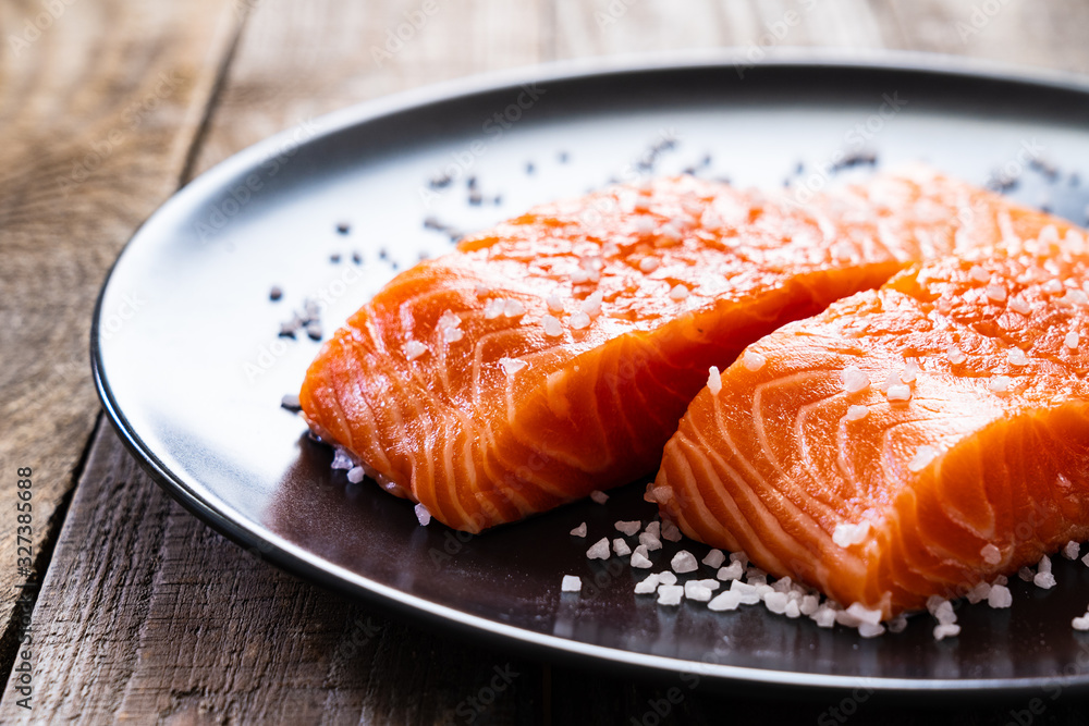 Fresh raw salmon steaks on wooden board Fresh raw salmon steaks on wooden board