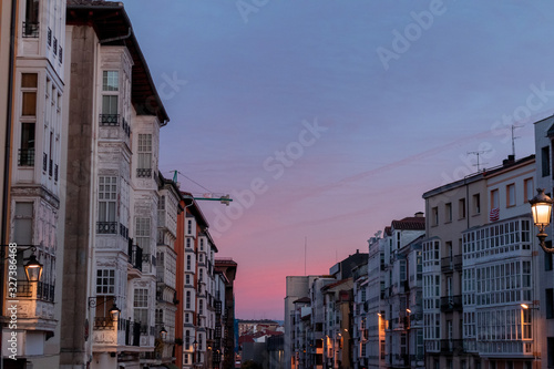 Pink sunset at the end of the street of typical and old buildings with glazed balconies in Vitoria-Gasteiz, Basque Country, Spain