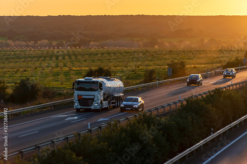 Tanker truck with dangerous goods circulating on the highway at sunset
