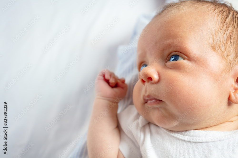 Close-up portrait of the little baby boy calm face laying in the crib Close-up portrait of the little baby boy calm face laying in the crib
