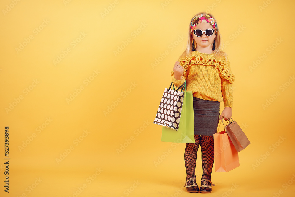 Child with shopping bags. Lady in a yellow sweater