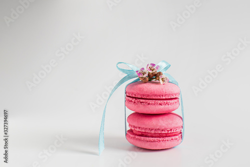 Two pink macaroons tied with a ribbon on a white background. Spring concept. present