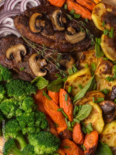 grilled meat steak with vegetables on a wooden board.