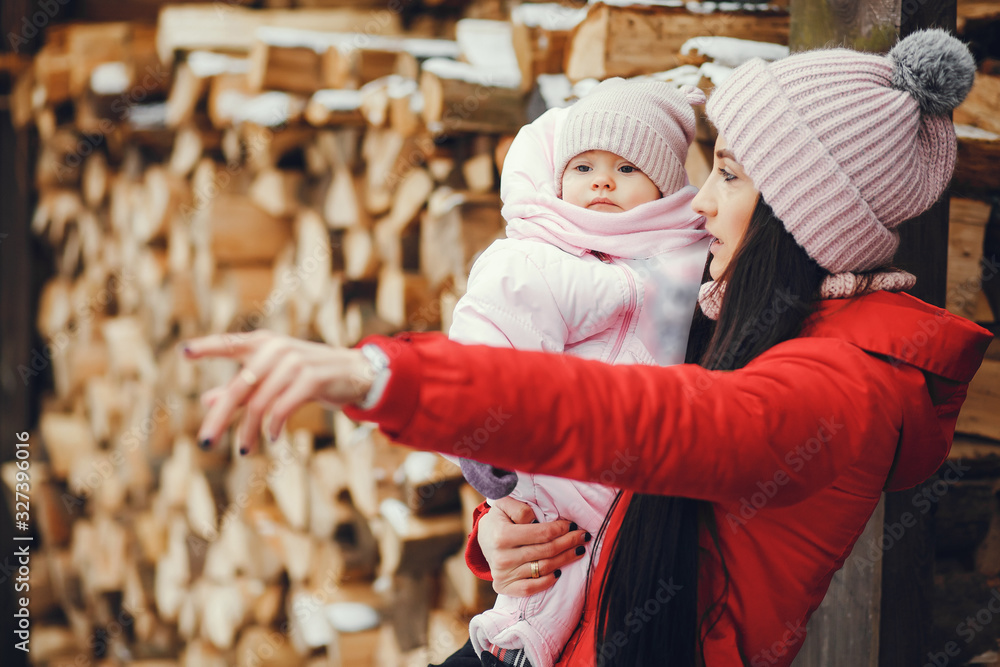 Obraz premium Cute family have fun in a winter park. Woman in a red jacket.