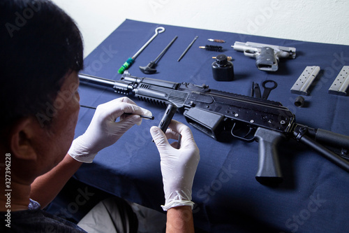 Tableau sur toile Gunsmith cleaning gun rifle and pistol assemble dismantle maintenance