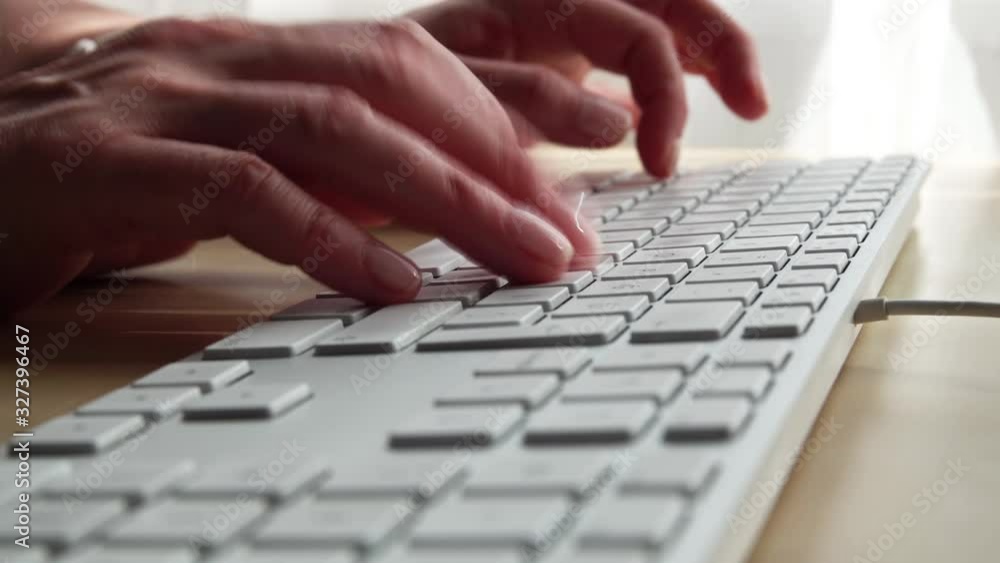Hands writing on a white keyboard, Close up from the right side Hands writing on a white keyboard, Close up from the right side