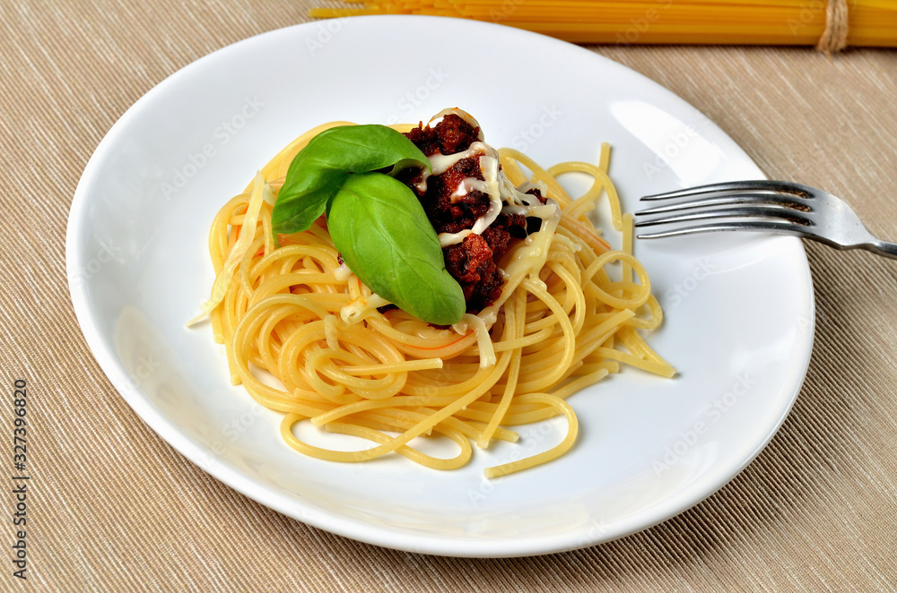 Close-up of spaghetti bolognese with cheese and basil. Italian traditional pasta meal.