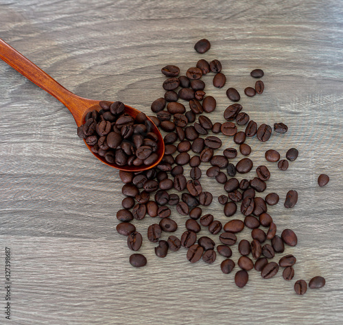 Coffee beans and a spoon on a wooden table