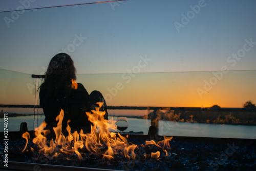 Young Woman enjoying sunset in Marina del Rey in Winter with fire pit
