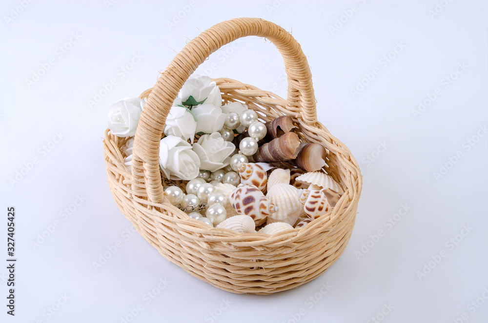 Basket of vines with flowers and shells on a gray background Basket of vines with flowers and shells on a gray background