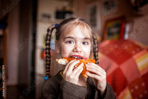 Girl dirty with berry jam eating homemade patty  indoor emotional lifestyle portrait
