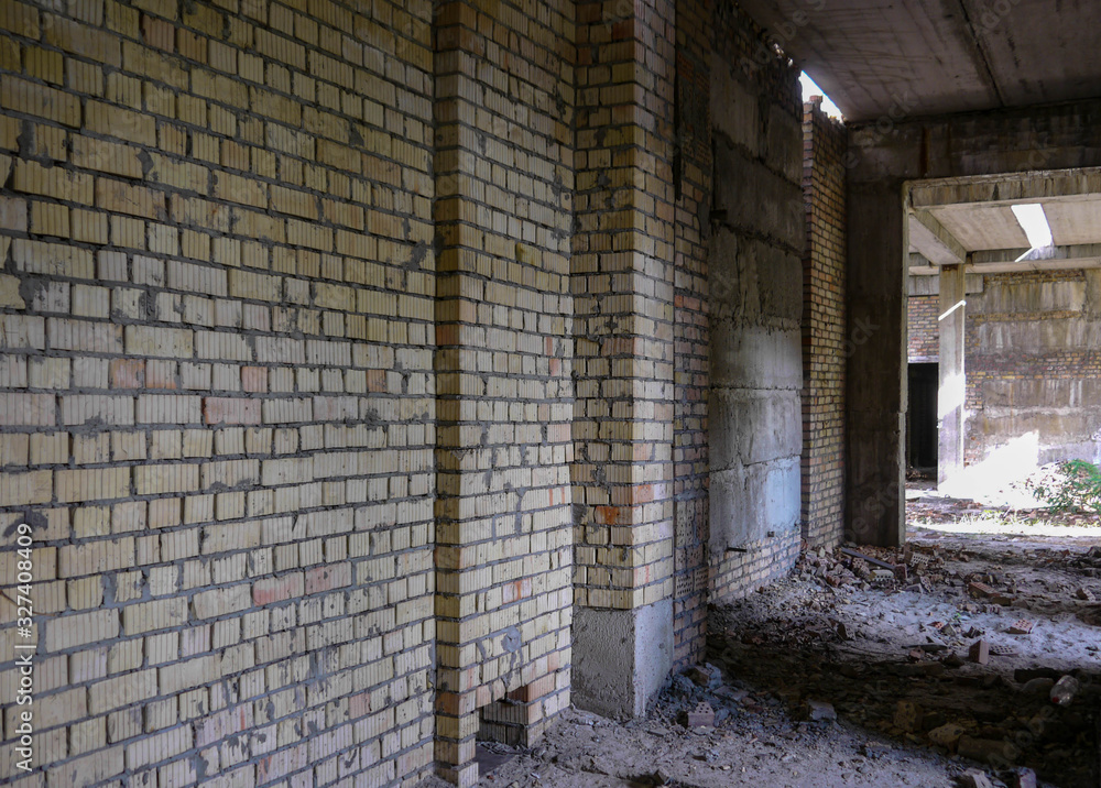 Brick wall in an empty corridor of the house under construction