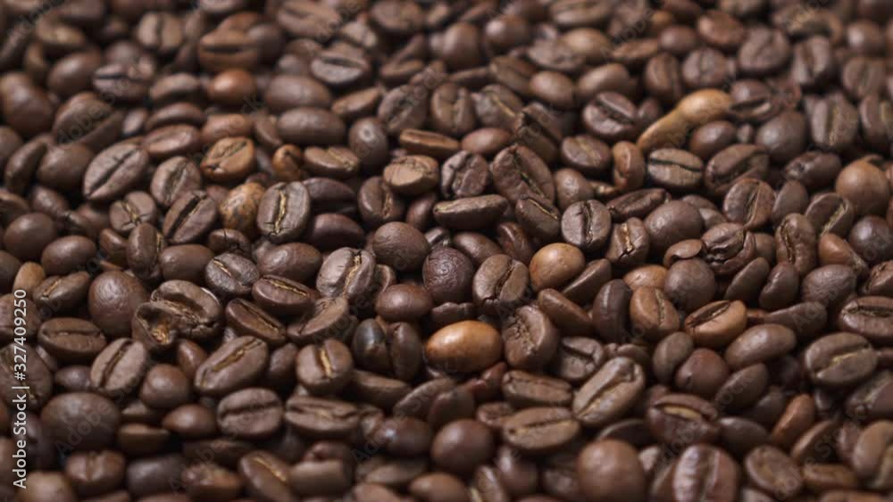 Dark roasted coffee beans move in a circle. Close up. Dark roasted coffee beans move in a circle. Close up.