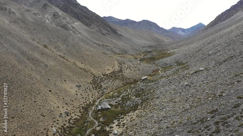 A reverse flight view inside Andes mountains at Limari Valley, south Atacama. An amazing wild scenery. Arid idyllic valleys with green farm fields feed in by the river at the bottom of the valley
 photo