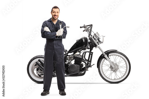 An auto mechanic standing with a customized motorbike