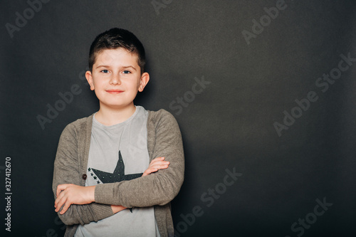Studio portrait of handsome young boy posing on black background