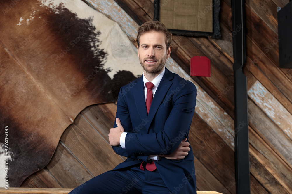 confident businessman crossing arms and smiling in a coffeeshop confident businessman crossing arms and smiling in a coffeeshop