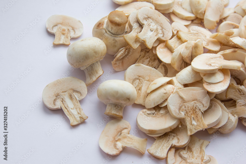 Raw fresh cut mushrooms at white background of the table Raw fresh cut mushrooms at white background of the table