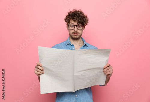 young casual guy reading newspaper photo