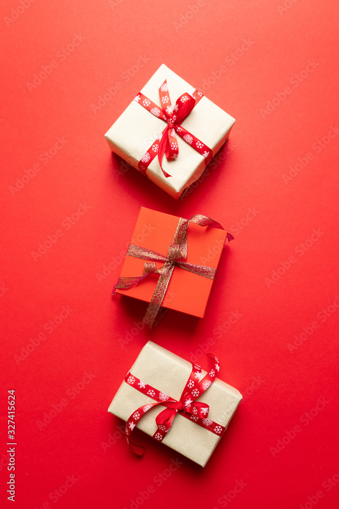 Red and white craft paper gift boxes on red background. Concept of national holiday, birthday, party, New Year Red and white craft paper gift boxes on red background. Concept of national holiday, birthday, party, New Year