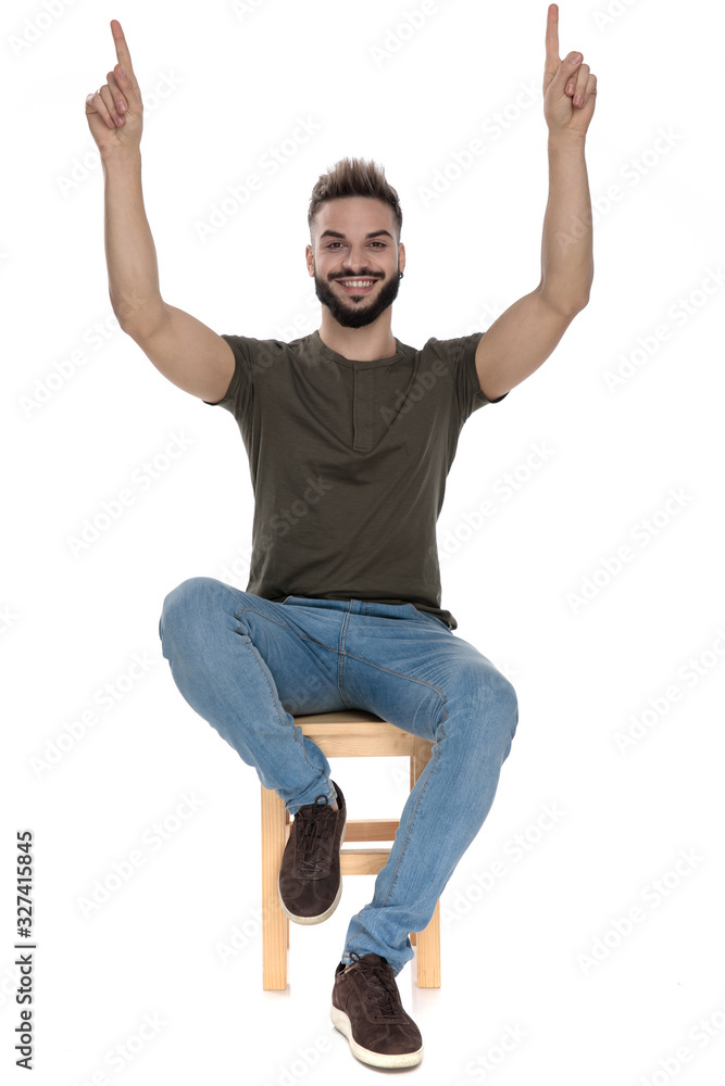 Cheerful casual man pointing up and smiling Cheerful casual man pointing up and smiling