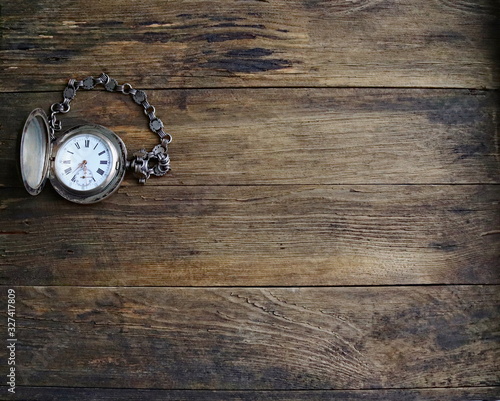 vintage silver pocket watch, old wooden background