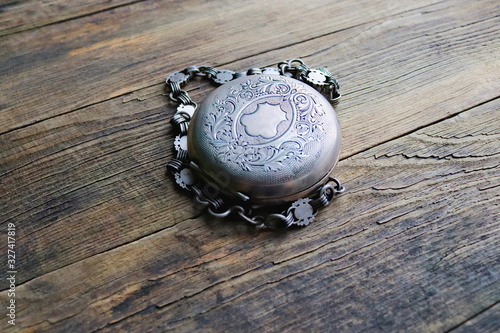 vintage silver pocket watch, old wooden background