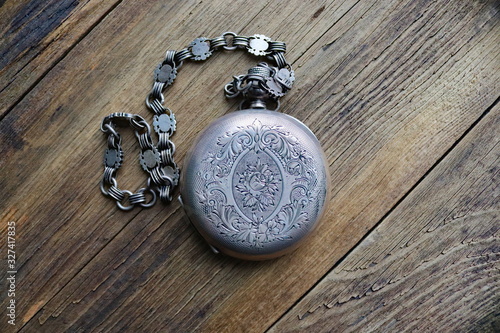 vintage silver pocket watch, old wooden background