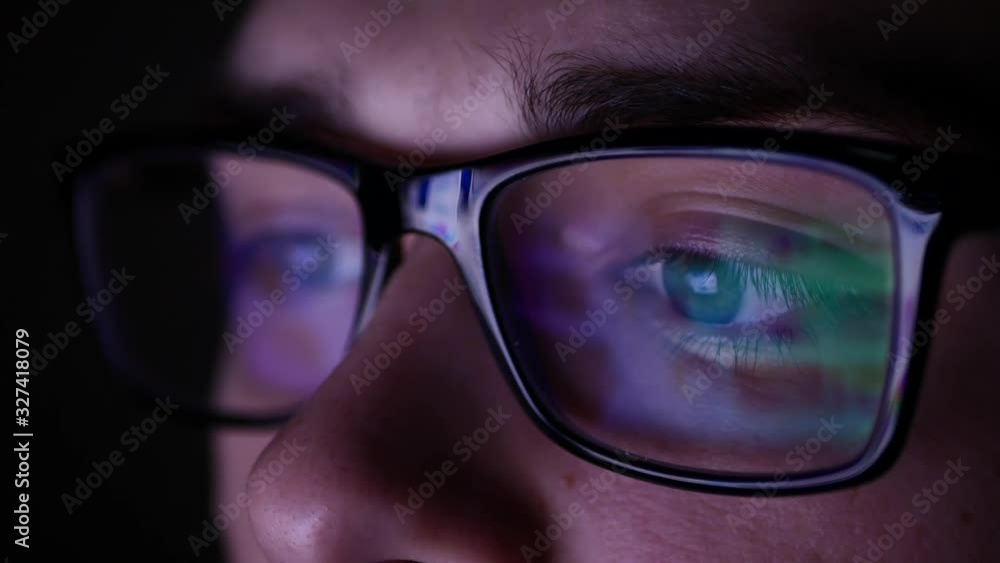 Man in glasses at night looking for a solution on the Internet. Man in glasses at night looking for a solution on the Internet.