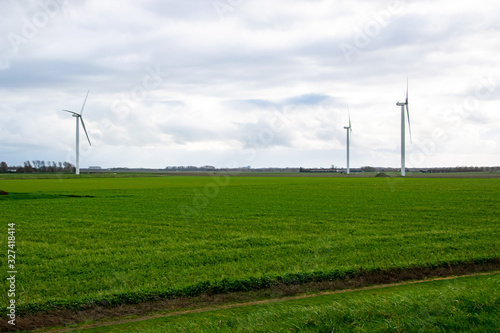 Green farming field with wind turbines