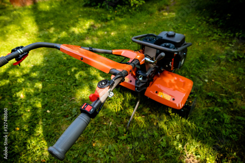 Wallpaper Mural garden with tiller machine. Garden tiller to work, close up.Abstract and conceptual of motor hoe at work. garden with rototiller , tiller tractor, cutivator, miiling machine. Man plowing the garden Torontodigital.ca