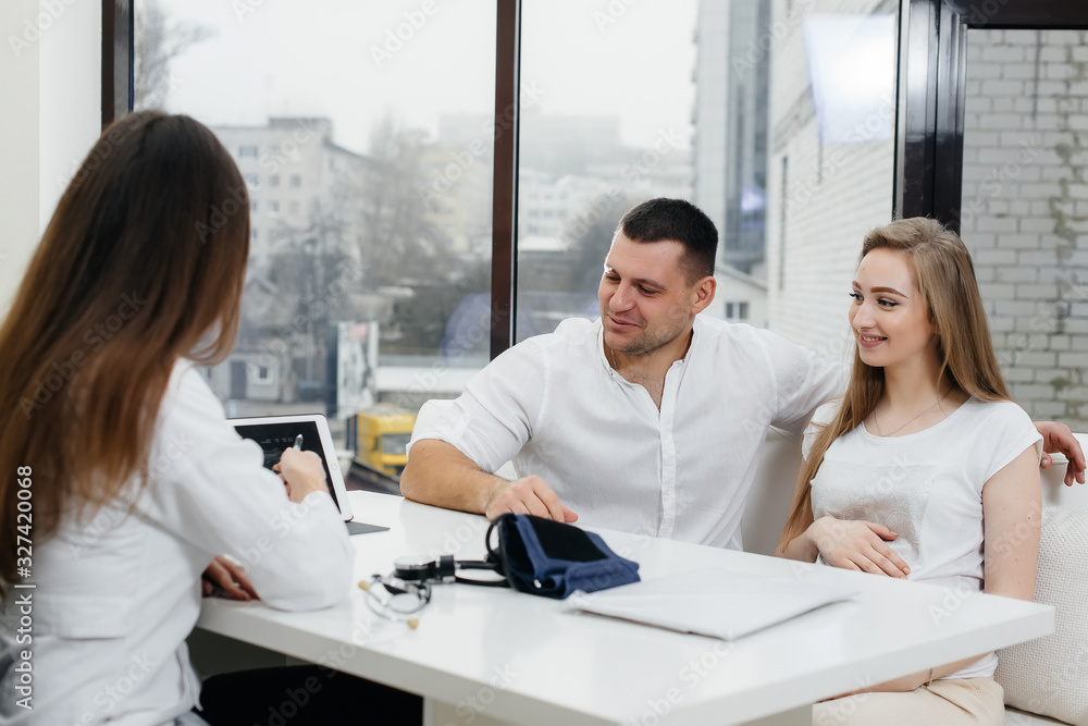 Fototapeta premium A young couple at a gynecologist's consultation after an ultrasound. Pregnancy, and health care