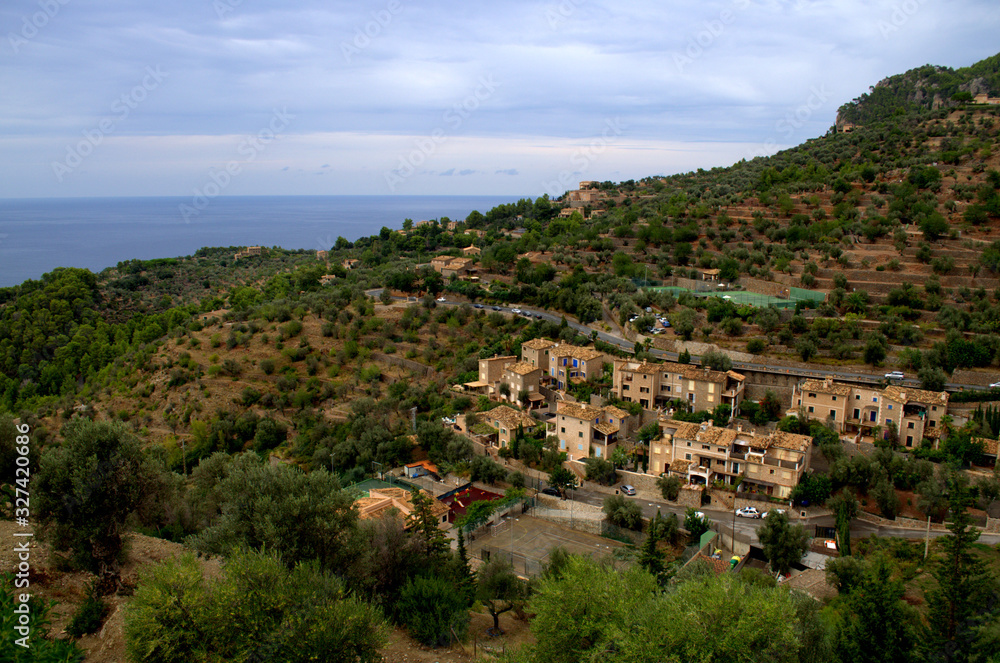 Aereal view of Deia town and mediterranean sea at the back