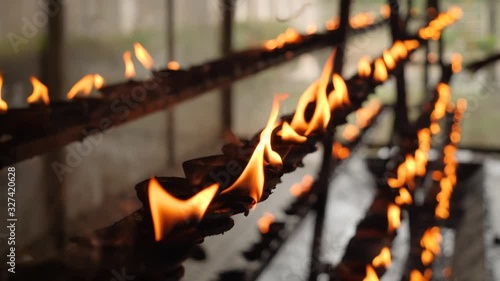 CLoseup 4k video of burning sacred fire in the oil lamps at buddhist or hindu temple