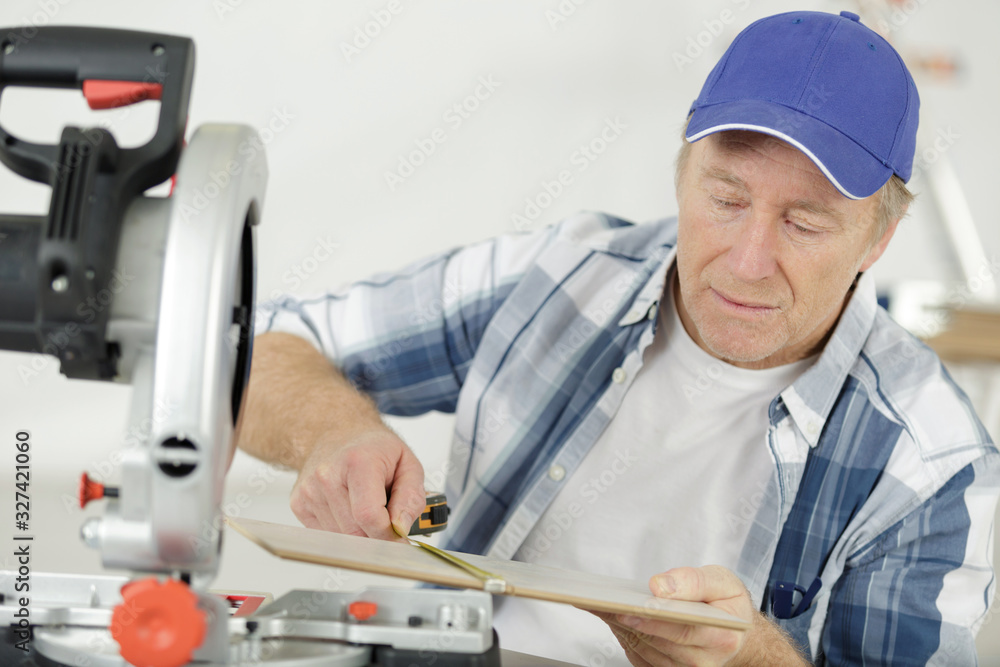 mature man using circular saw in workshop mature man using circular saw in workshop