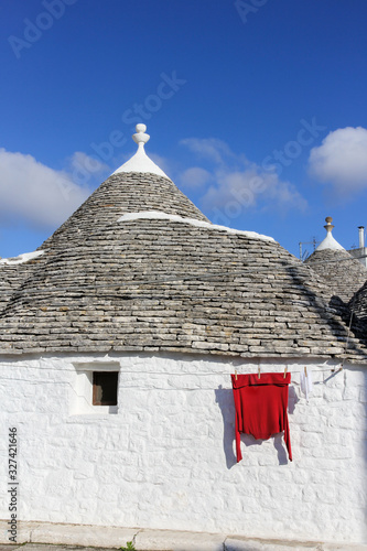 A red cloth hanging outside a Trulli house of Alberobello - UNESCO World Heritage. Alberobello, Italy. photo