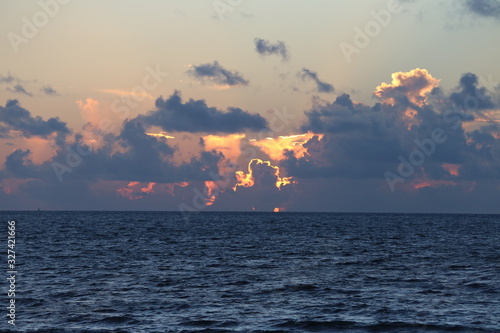 Golden sunrise through clouds over a deep blue sea in the Atlantic Ocean