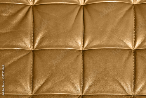 Close-up of gold leather sofa upholstery with square background texture