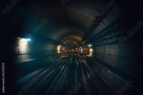 Dubai metro tunnel in blurred motion, view from first wagon, subway tracks.