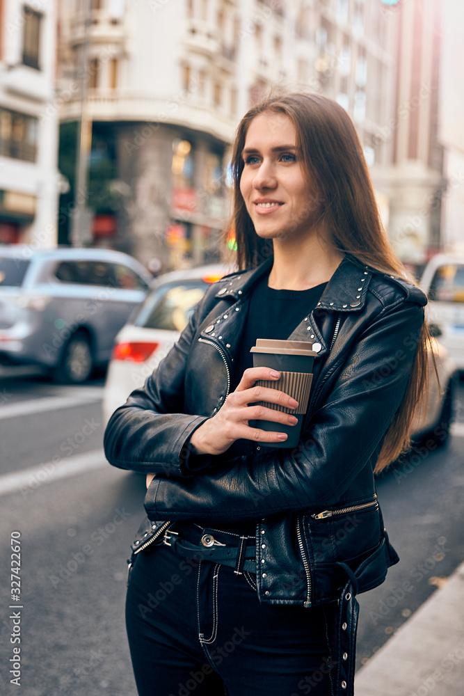 Young blonde girl smiling in the street with a coffee. Young blonde girl smiling in the street with a coffee.