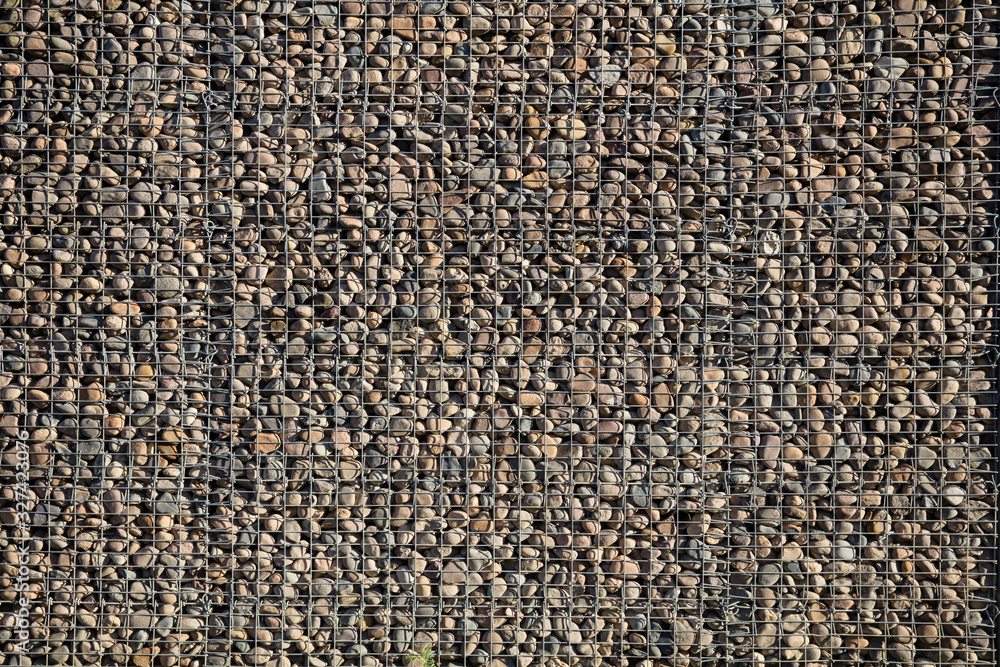 Nahaufname einer Gabionenfassade bei Sonne Nahaufname einer Gabionenfassade bei Sonne